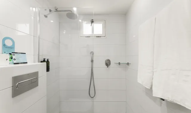 En suite bathroom with shower, shower gel and towels 